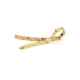 Glistening Star gold titanium bracelet unclasped and folded to display curved X-link pattern and embedded negative ion elements.