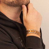 Close-up of bracelet on wrist, worn by model touching chin, showing detailed design and fit on wrist.