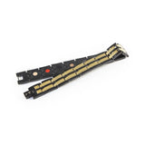 Aegis negative ion bracelet with black stainless steel and gold, unclasped and folded for display.