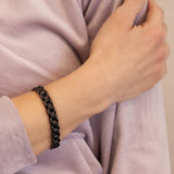 Close-up of female model with Black Knight bracelet on wrist, showing reflective polished edges and subtle matte center design.