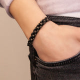 Female model wearing the Black Knight bracelet, featuring matte black segments bordered by polished black stainless steel rows.