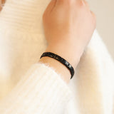 EverStrength bracelet on wrist showing sleek black stainless steel design.