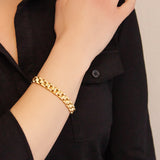 Close-up of female model with Golden Breath bracelet on wrist, emphasizing the elegant dual-finish gold link design.